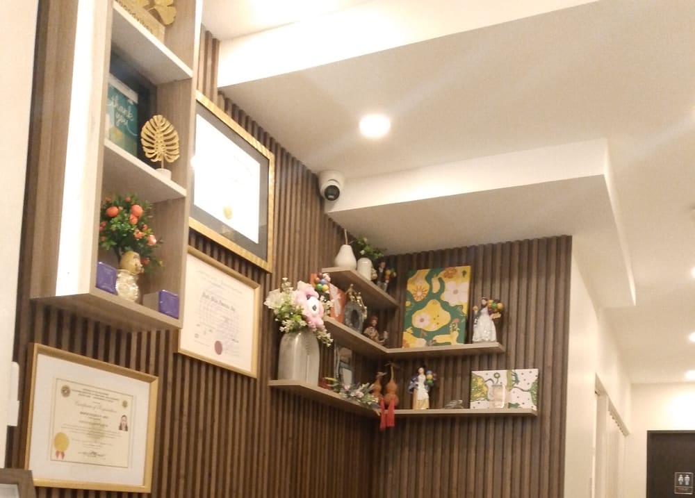 The clinic's waiting lounge with walnut slat walls, framed diplomas and shelves